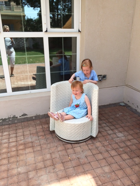 Pigerne leger i haven, mens de venter på Mor