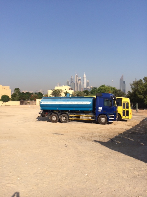 Vandvogn - og bag den en af de busser, som kører arbejdere rundt til byggepladserne